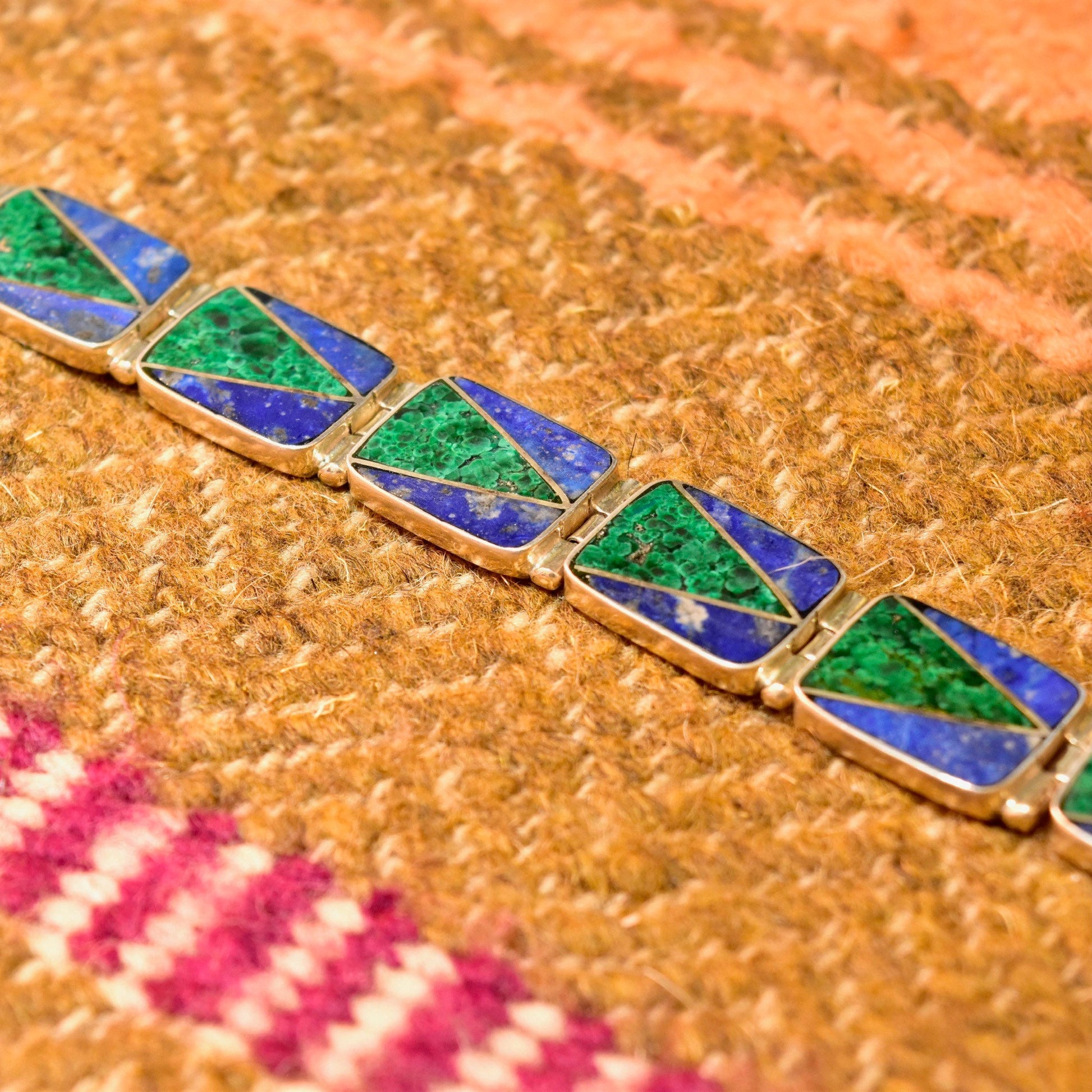 Vintage sterling silver link bracelet with geometric malachite and lapis lazuli inlay on a knit textile background