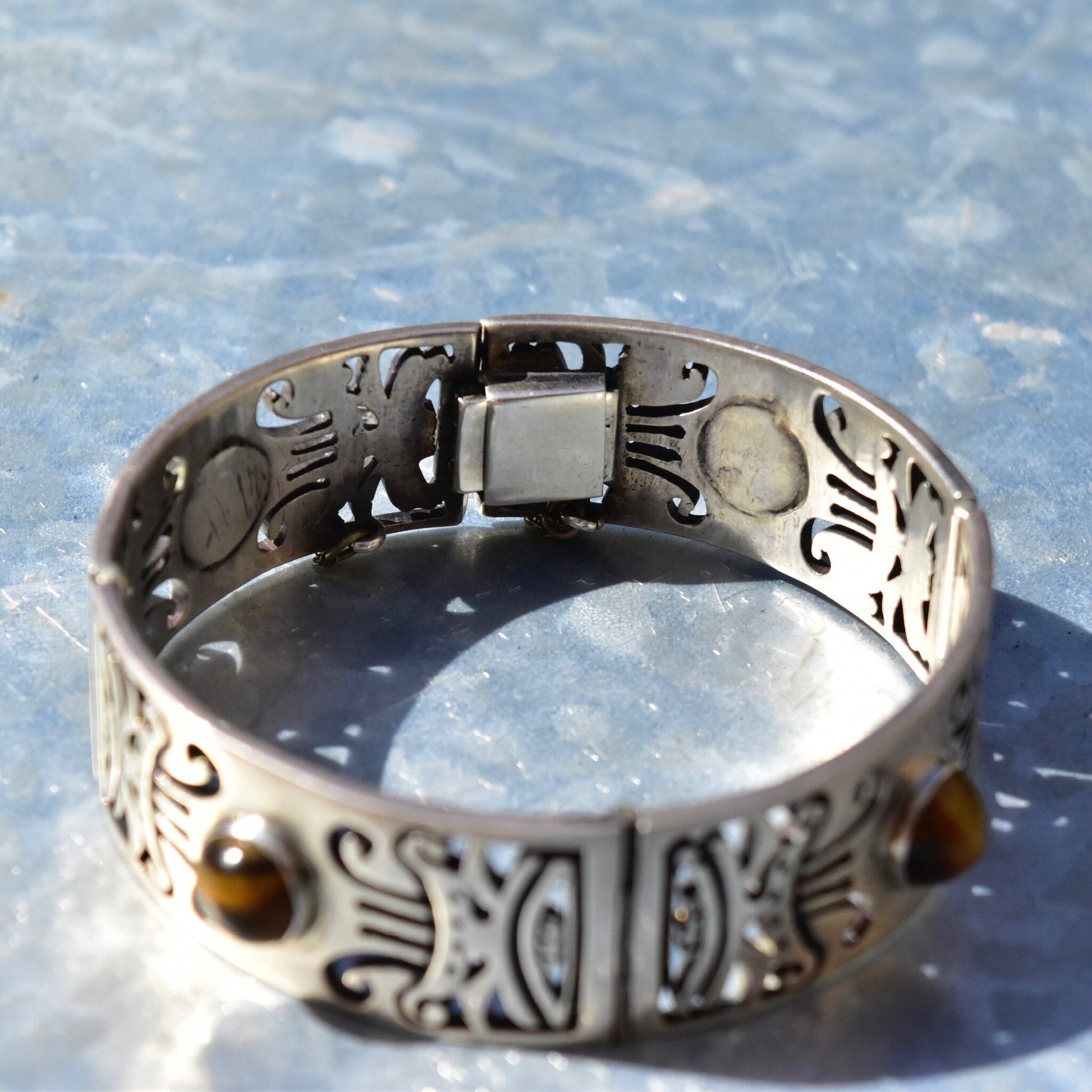 Vintage TAXCO Sterling Silver Tiger's Eye Link Bracelet with tribal motifs on heavy silver closed cuff/bangle and security chain clasp, measuring 7 1/2 inches in length.