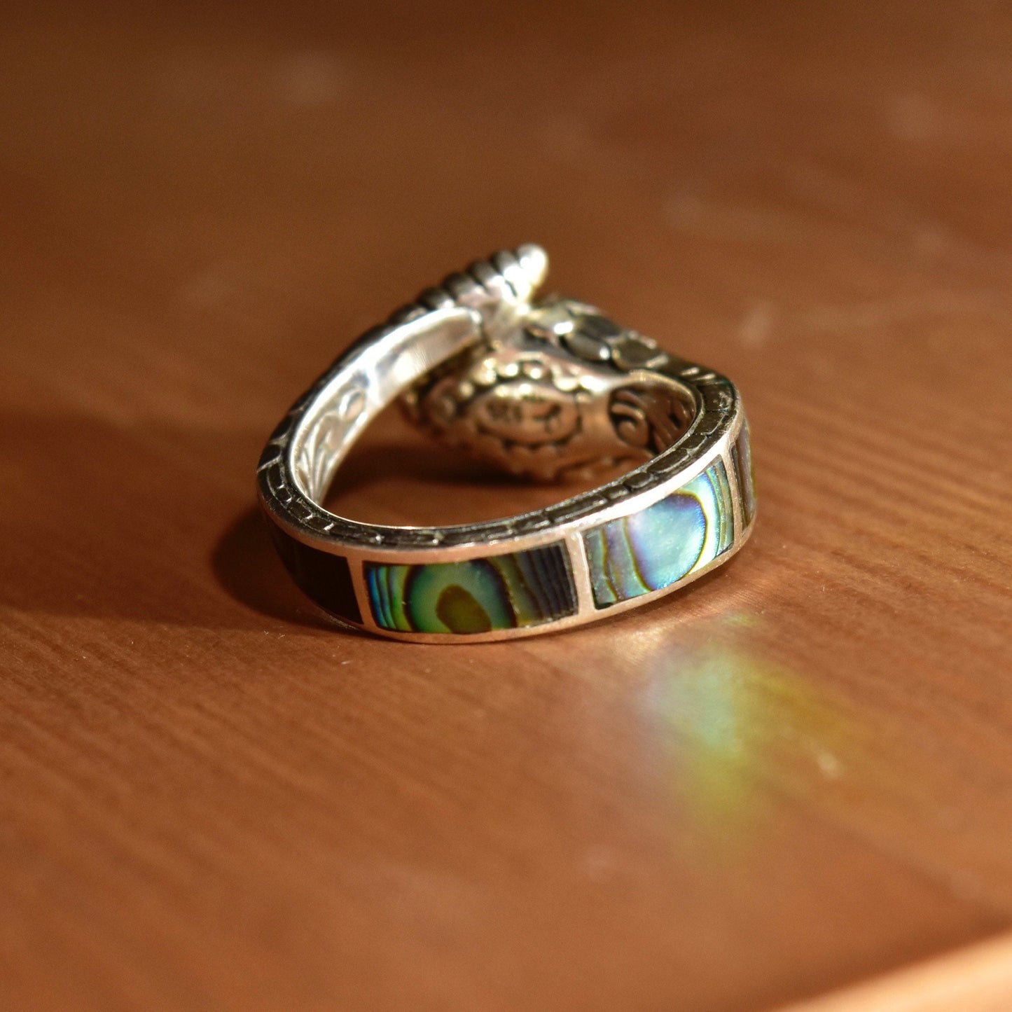 Vintage sterling silver snake ring with 18K gold accents and iridescent abalone shell inlay, featuring engraved rattlesnake coil design and gold eyes, size 7 1/2 US.