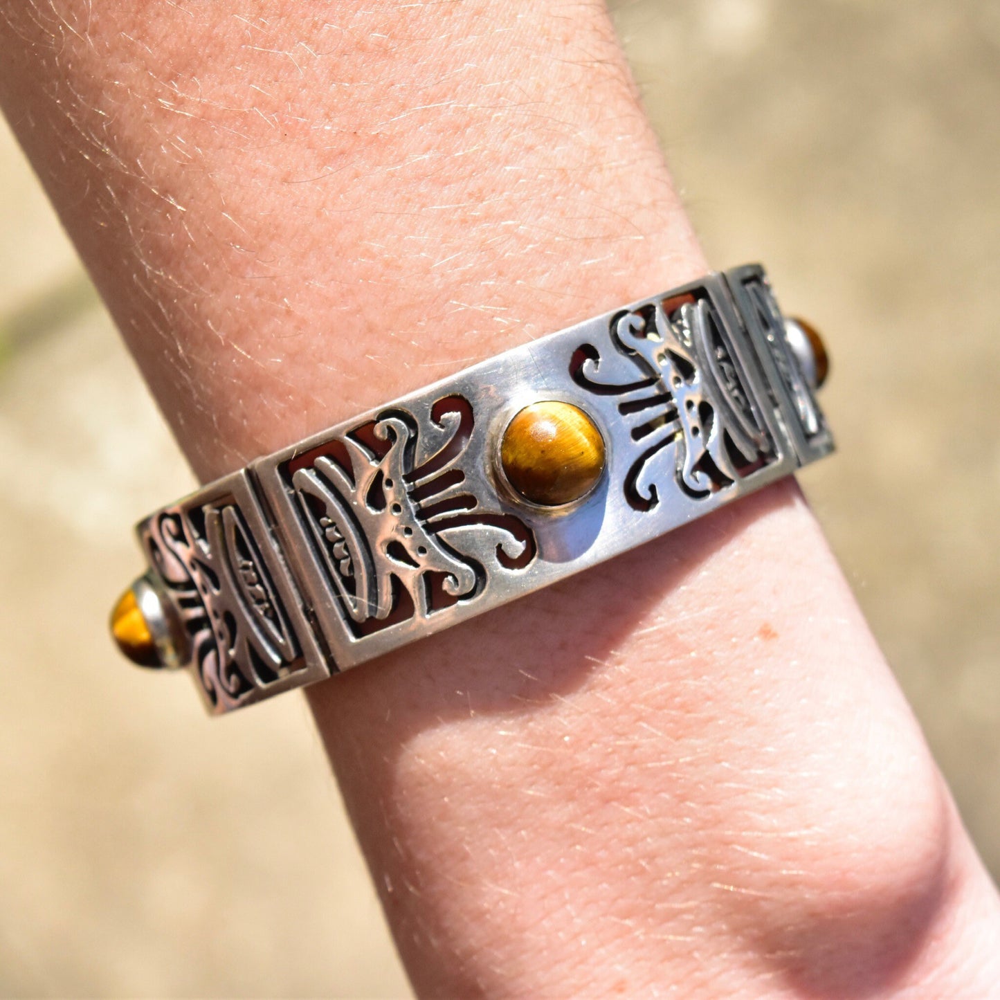 Vintage TAXCO Sterling Silver Tiger's Eye Link Bracelet with tribal motifs and heavy silver closed cuff/bangle style, featuring a security chain clasp, measuring 7 1/2 inches in length.