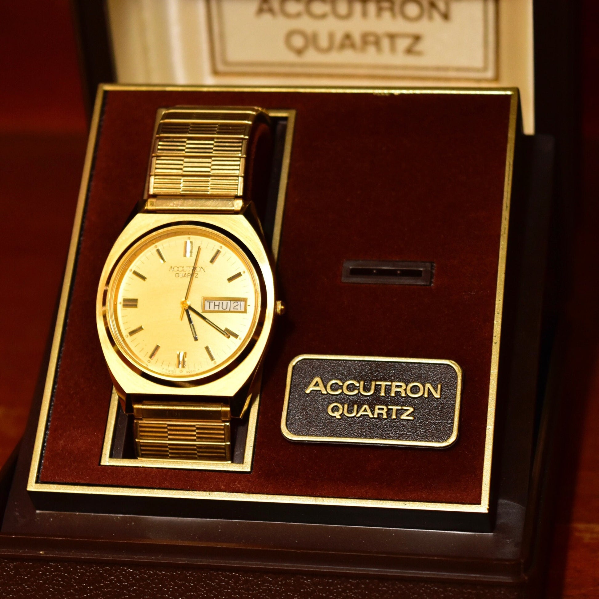 Vintage 1988 Bulova Accutron gold tone Swiss quartz watch with day/date feature, displayed in original Accutron Quartz box with papers, paired with a Speidel two-tone stretch band, sized for a 7-inch wrist.