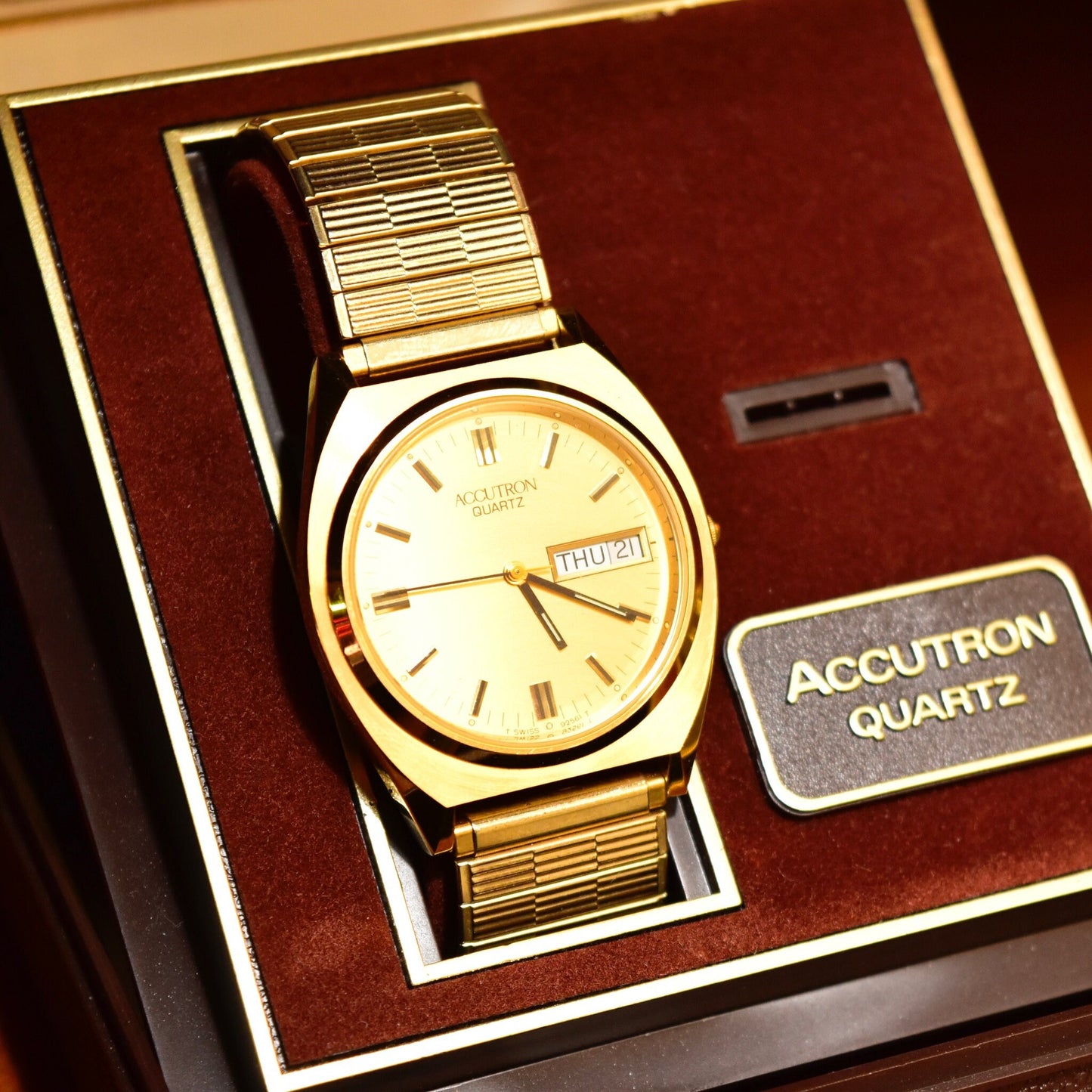 Vintage 1988 Bulova Accutron gold tone Swiss quartz day/date wristwatch in original box with papers, featuring a champagne dial and two-tone Speidel stretch band, 7 inches in length.