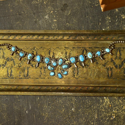 Vintage Navajo squash blossom necklace with natural blue turquoise stones set in coin silver, measuring 29 inches long, showcasing intricate Native American old pawn jewelry craftsmanship from the southwestern United States.