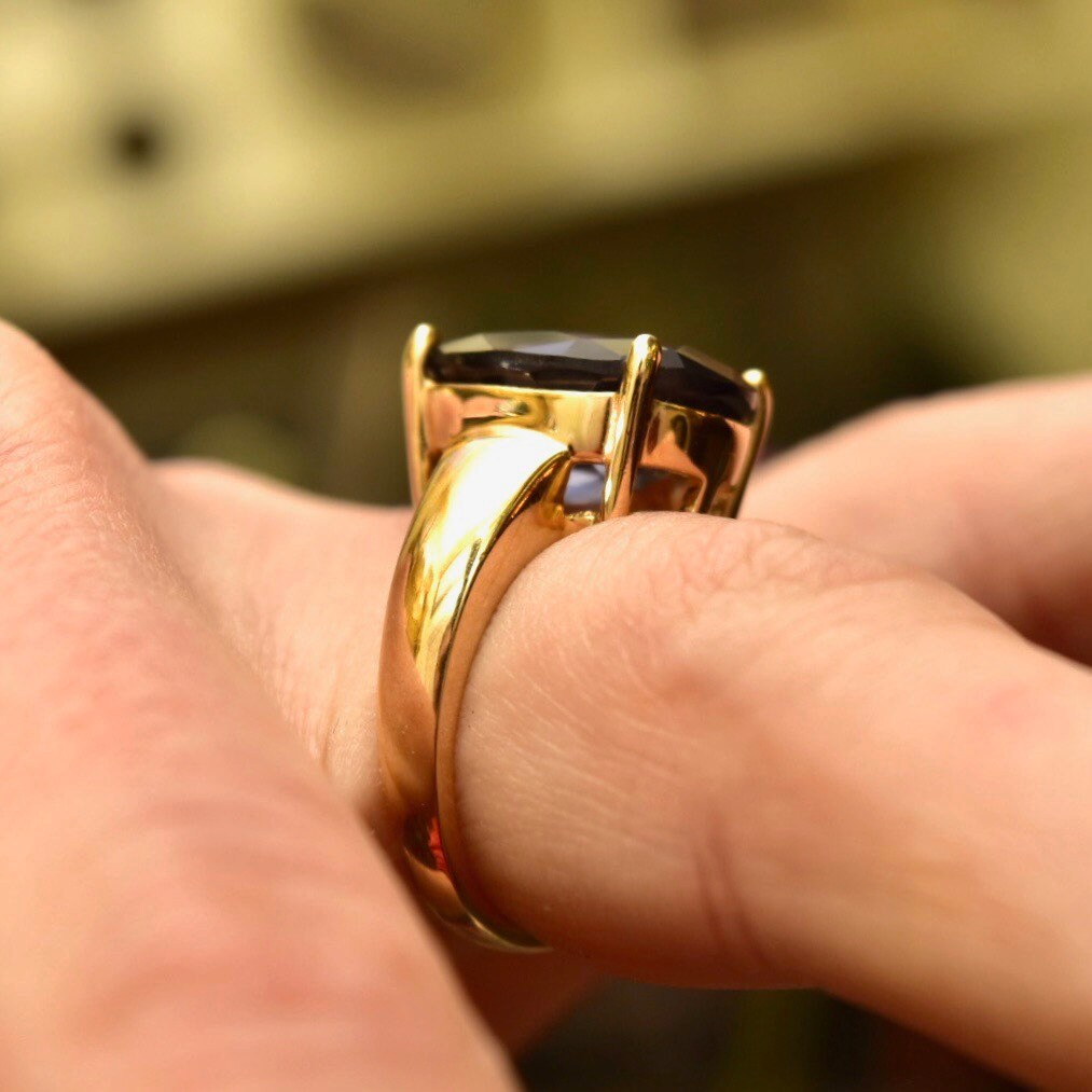 Vintage gold plated sterling silver cocktail ring with oval-cut blue simulated gemstone on a hand, size 7 US.