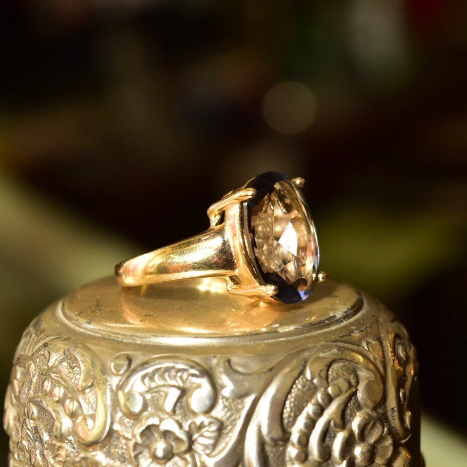 Vintage gold plated sterling silver cocktail ring featuring an oval-cut blue gemstone, with an ornate embossed band design, in a size 7 US.