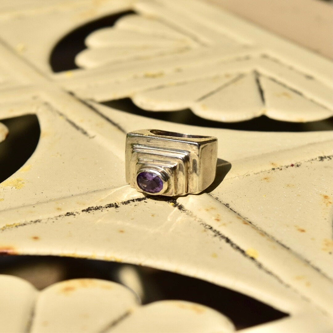 Vintage modernist sterling silver ring with chunky oval cut amethyst set in a textured dome design, featuring a step pattern. Size 6 1/2 US.