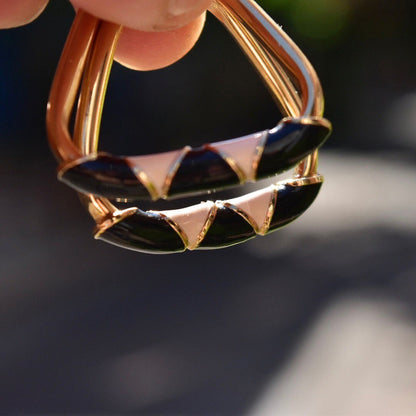 14K gold hoop earrings with black and beige enamel triangle designs, statement modernist style, 35mm in diameter, held between fingers to show detail.