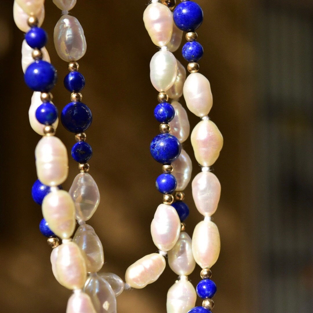 Vintage 14K gold necklace with knotted fresh water baroque pearls and polished lapis lazuli beads, accented by gold beads, measuring 29 inches in length.