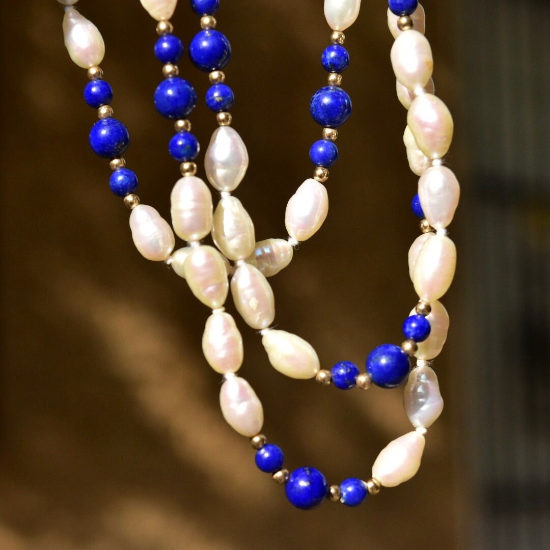 Vintage 14K fresh water pearl and lapis lazuli knotted bead necklace featuring baroque pearls, polished lapis lazuli beads, and gold bead accents, measuring 29 inches in length.