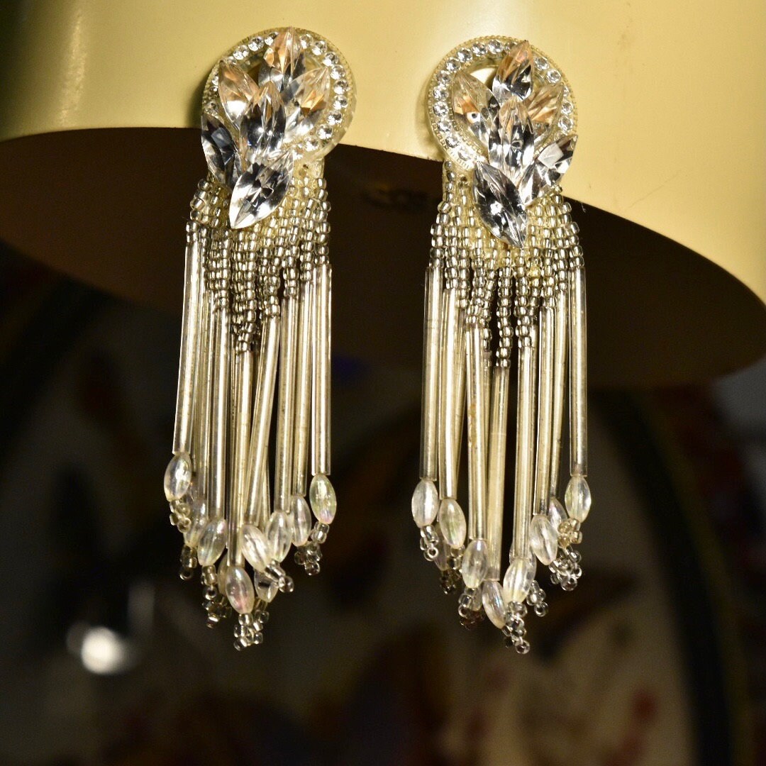 Vintage chandelier clip-on earrings with beaded teardrop tassels and ornate crystal designs, measuring 3 3/4 inches long, costume jewelry.