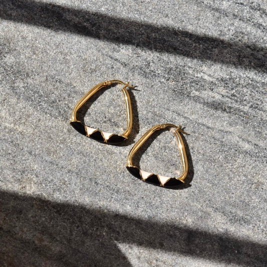 14K gold triangle hoop earrings with black and beige enamel designs, modern statement hoops measuring 35mm in diameter, displayed on gray textured background.