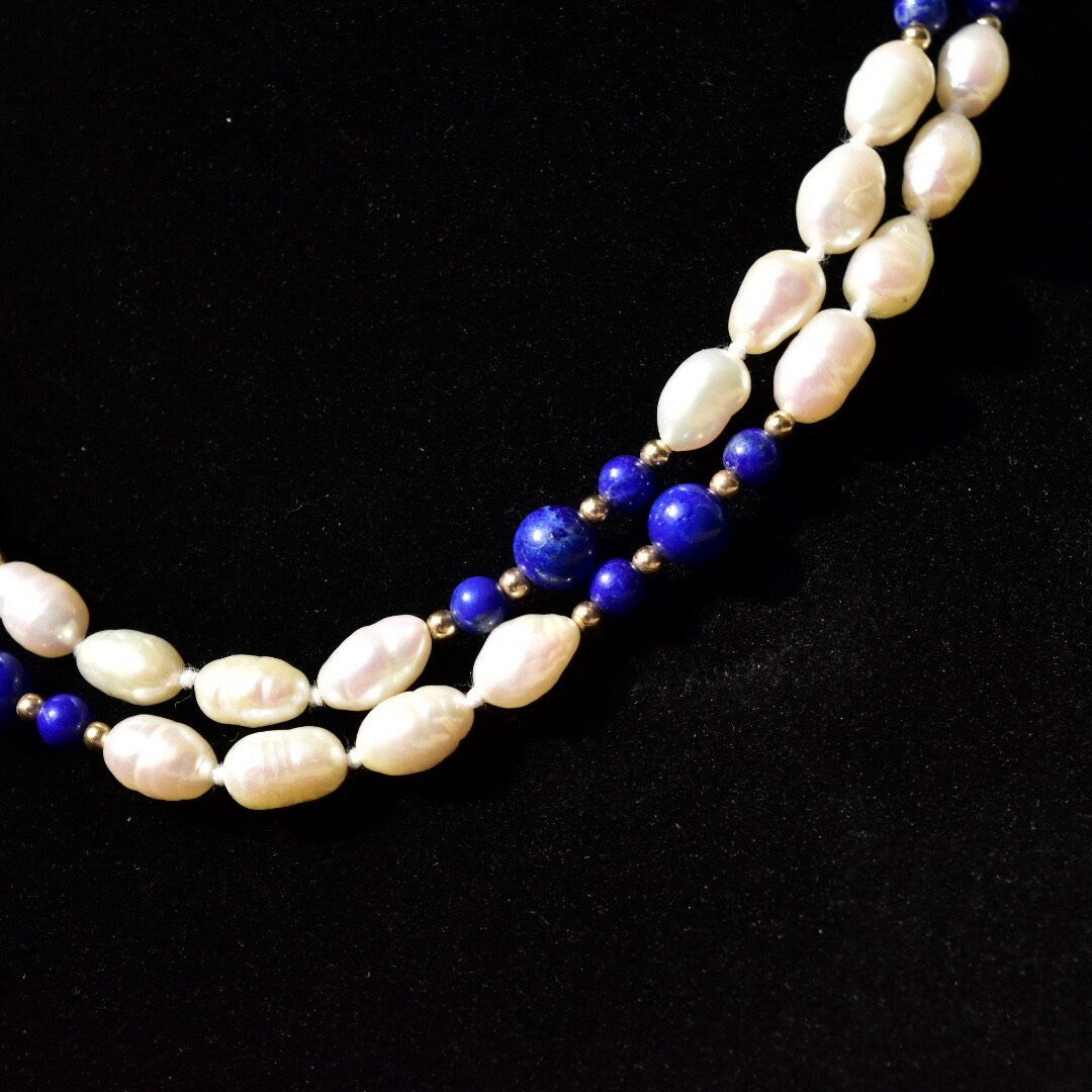 Vintage 14K gold necklace with knotted freshwater baroque pearls and polished lapis lazuli beads, accented by gold beads, measuring 29 inches in length.