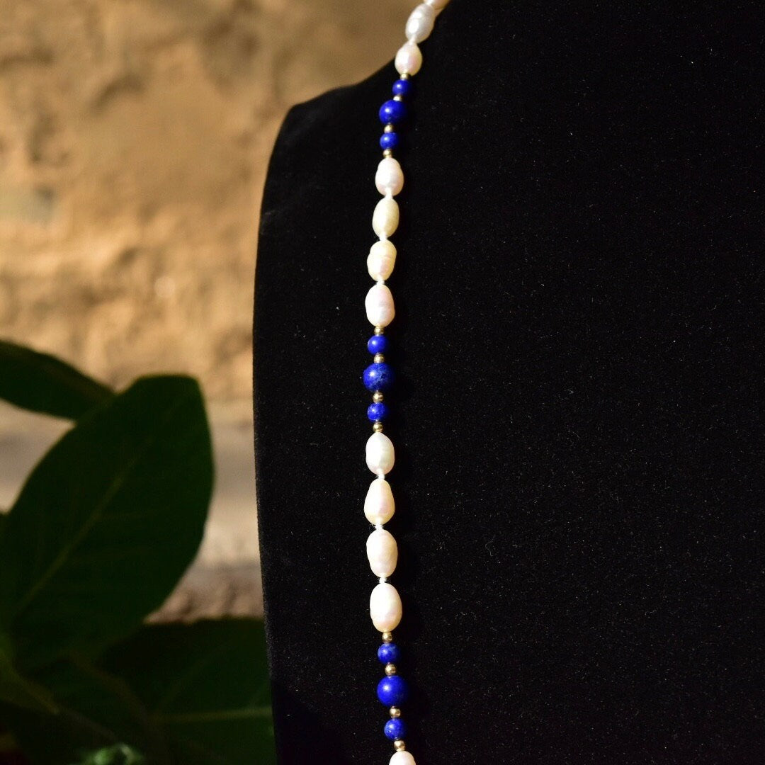 Vintage 14K fresh water pearl and lapis lazuli knotted bead necklace with baroque pearls, polished lapis lazuli beads, and gold bead accents, measuring 29 inches in length, displayed against a dark background.