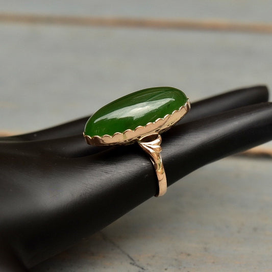 18K yellow gold ring featuring a dark green marquise-shaped nephrite jade cabochon set in a scalloped bezel, mid-century vintage jewelry, ring size 5 1/4 US.