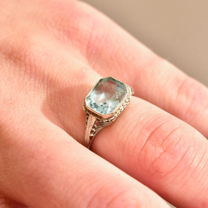 Antique Art Deco 14K white gold filigree ring with a pale blue faceted aquamarine gemstone in an intricate setting, size 6 1/2 US, perfect as a March birthstone ring.