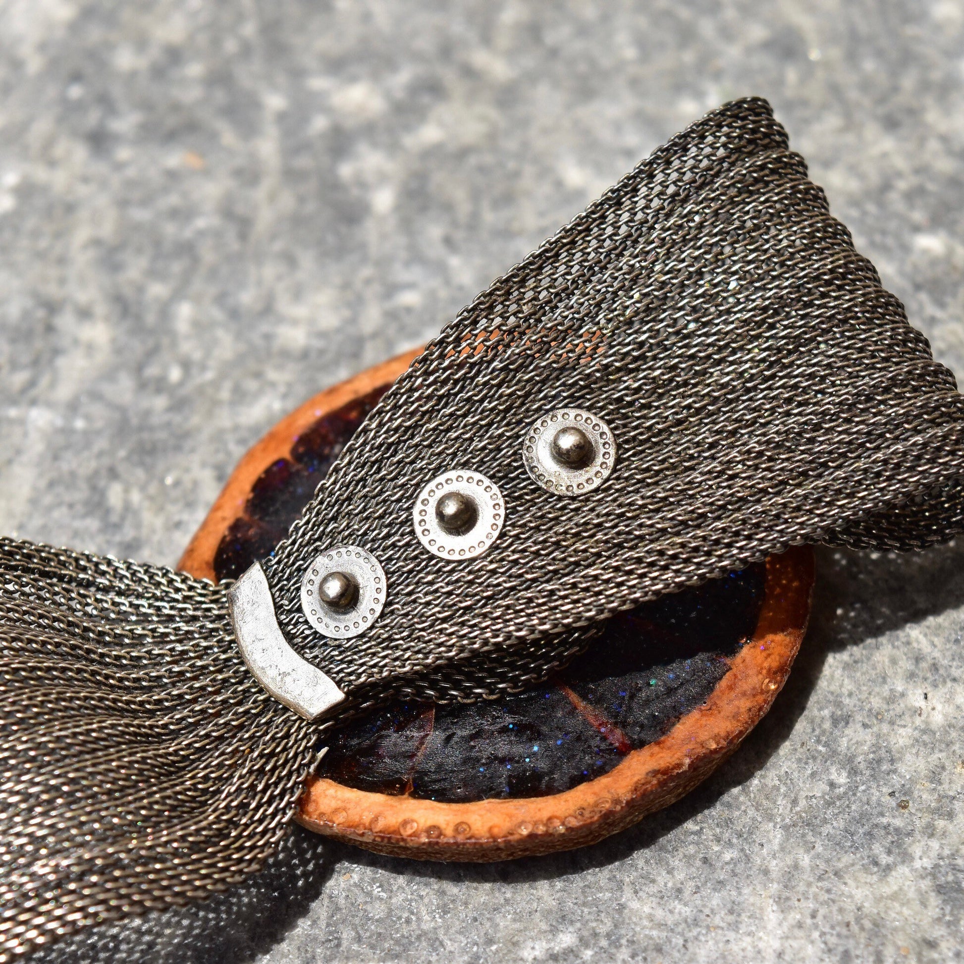 Unique sparkly preserved orange slice snap cuff bracelet with silver mesh band and iridescent purple glaze, adjustable from 6 1/2 to 7 1/4 inches long.