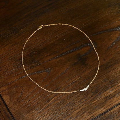 14K yellow gold diamond bar collar necklace with shared prong setting on delicate 2mm Singapore chain, elegant 17 1/2 inch length.