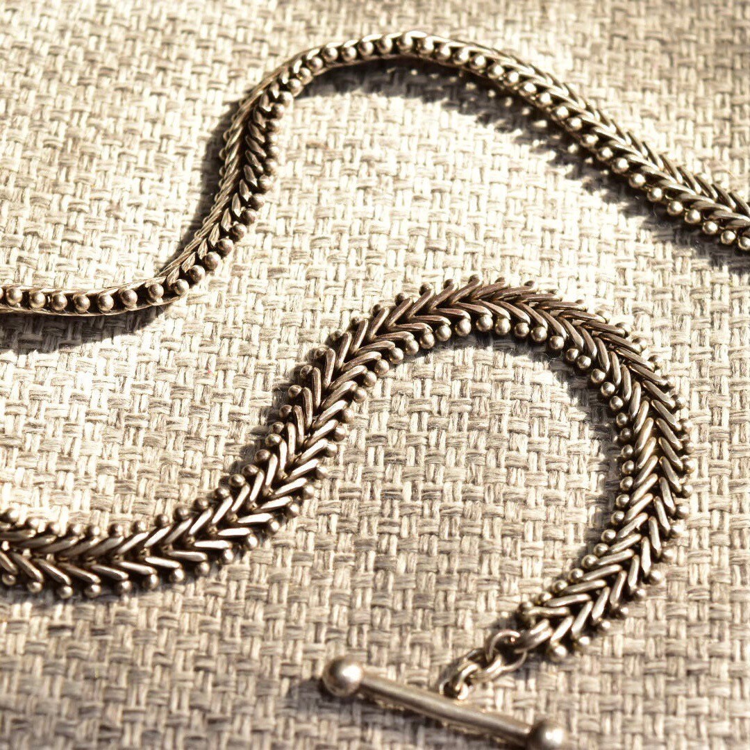 Sterling silver foxtail chain necklace with toggle clasp on textured burlap fabric, 17 inches long