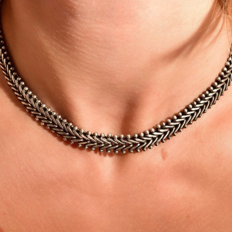 Close-up view of a sterling silver foxtail toggle chain necklace against a person's neck, showcasing the intricate woven pattern and industrial style of the solid silver links. The necklace measures approximately 17 inches long.