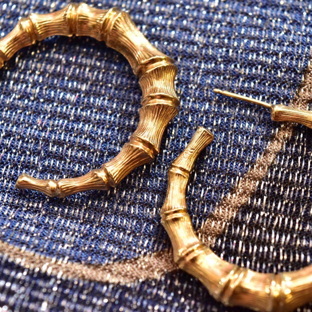 14K yellow gold bamboo hoop earrings on denim background, 35mm vintage statement jewelry studs