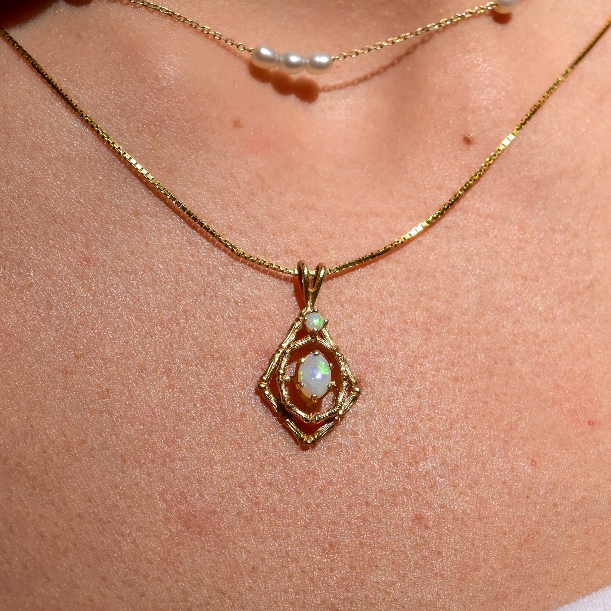 10K yellow gold pendant necklace with bamboo motif featuring two white opal cabochon stones, estate jewelry piece measuring 26mm in length.