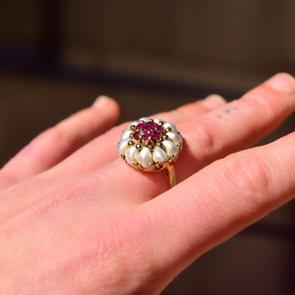 14K yellow gold pearl and ruby cluster ring featuring a domed floral design on a hand, estate jewelry sized 9 US.