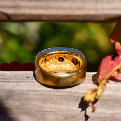 18K gold-plated modernist diamond signet ring with chunky textured band and circular cutouts, displayed on a wooden surface with autumn leaves, size 9 US.