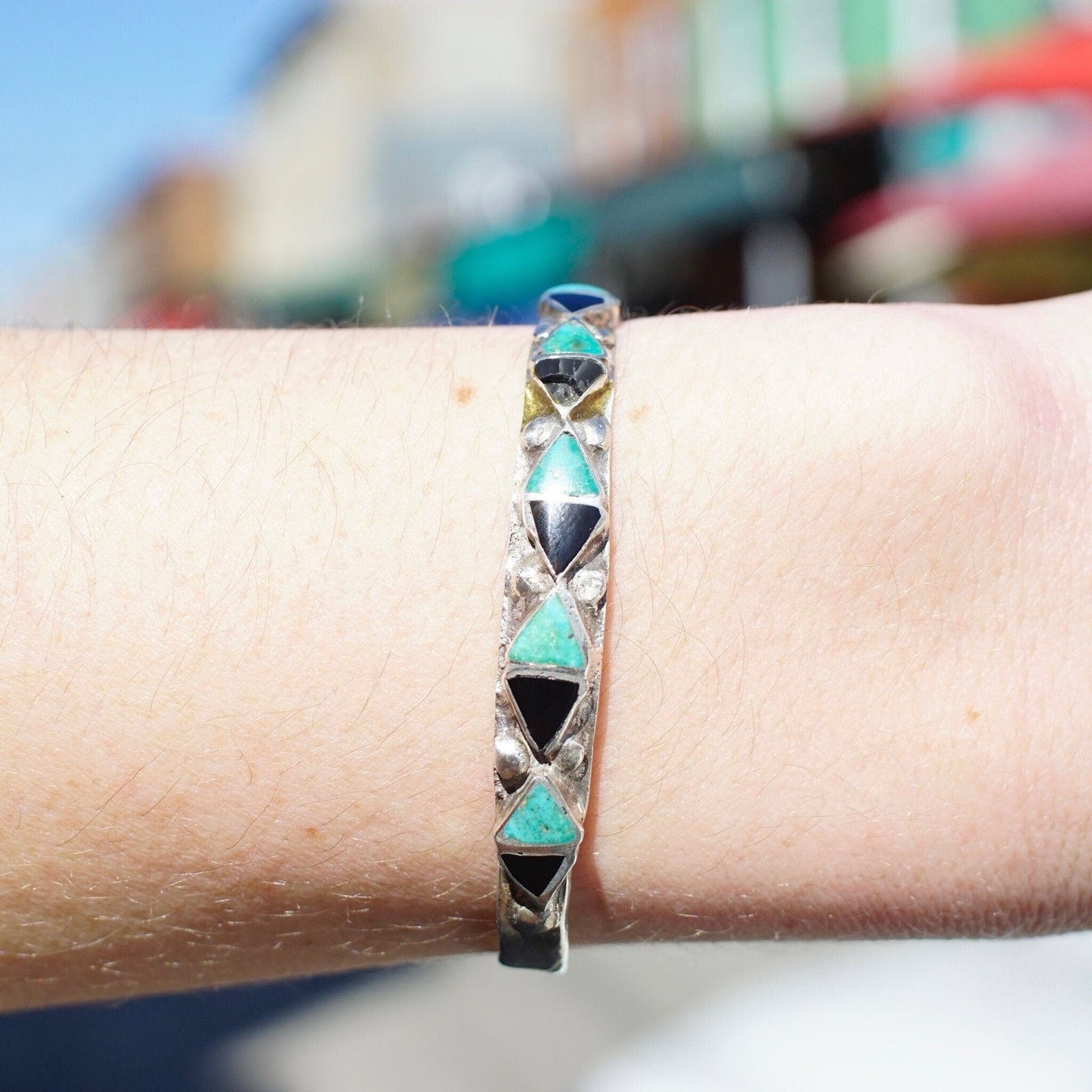 Vintage Zuni turquoise, onyx and silver cuff bracelet with triangle inlay pattern on wrist, 4 3/4 inches long.