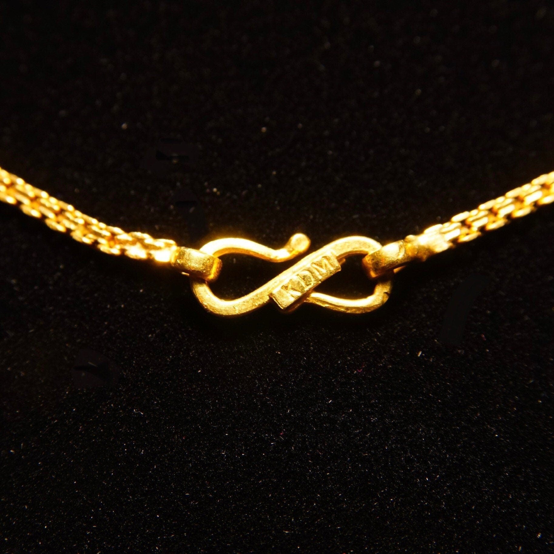 Vintage 22K yellow gold Bombay Bismark chain necklace with 2mm flat fence chain links, made in India by KDM, measuring 16 1/4 inches long, shown against a black background.