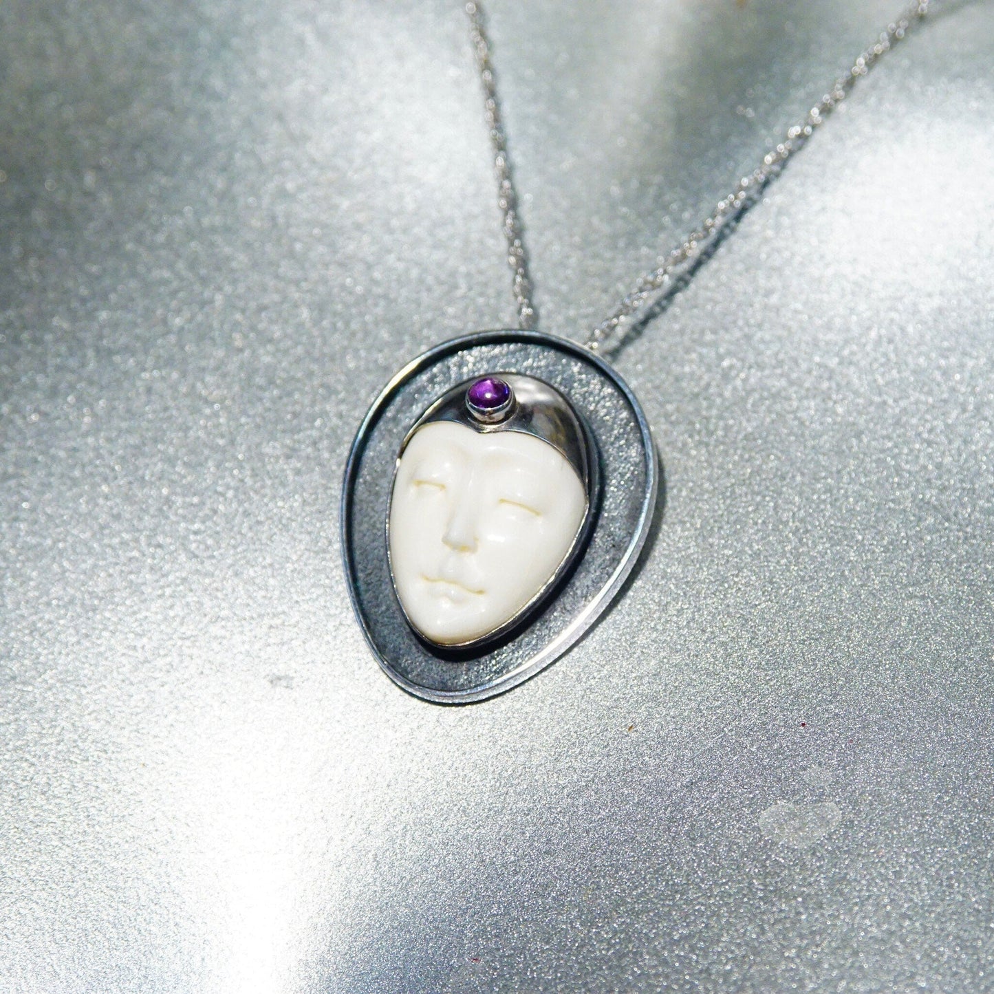 Vintage Sajen sterling silver pendant featuring carved bovine bone in a moon goddess design with amethyst accent, unique extraterrestrial-inspired 925 jewelry on silver chain
