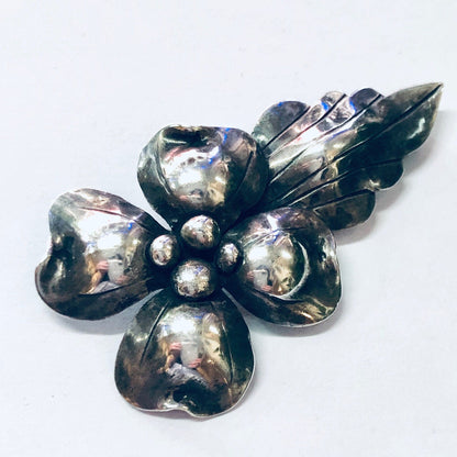 Vintage silver flower brooch with textured petals and spherical accents, likely from John Wanamaker department store, displayed on white background