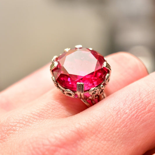 Art Deco pink ruby cocktail ring in 10K white gold ornate filigree setting, size 6 3/4 US, featuring a large synthetic ruby gemstone.
