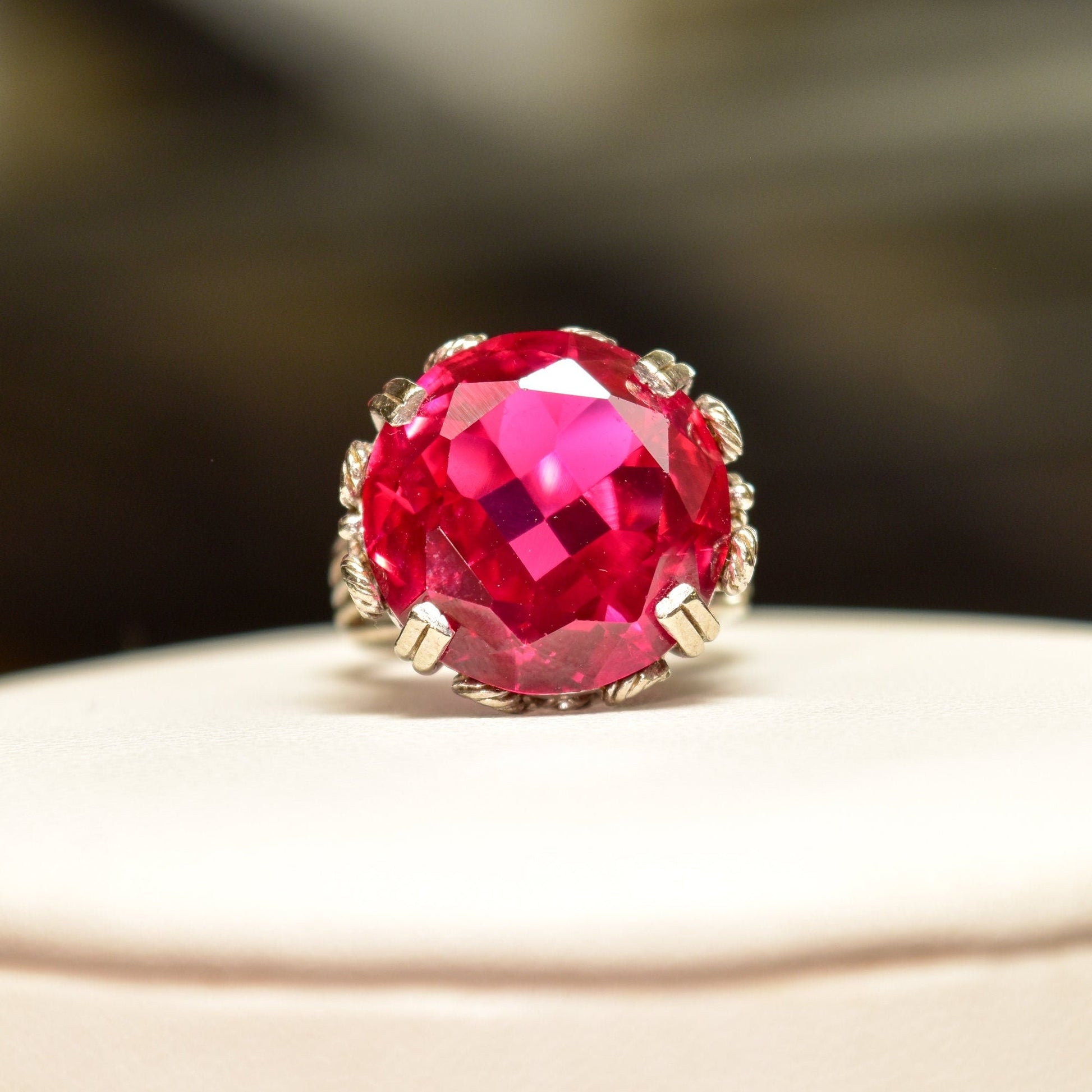 Ornate filigree 10K white gold cocktail ring with large, round faceted pink synthetic ruby gemstone, size 6 3/4 US, shown on white background.