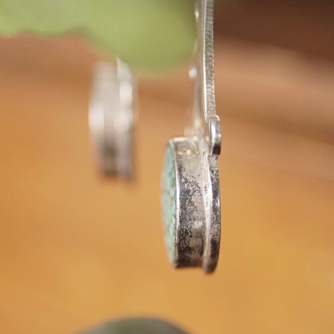 Vintage sterling silver dangle earrings with turquoise inlay and abstract cutout design, made in Taxco, Mexico.