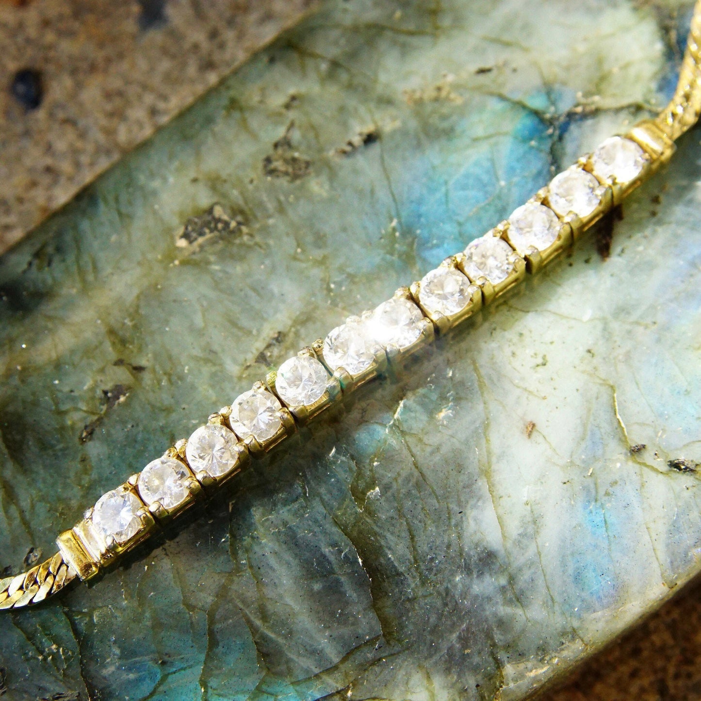 Vintage gold plated sterling silver cubic zirconia diamond bar bracelet with 2.5mm herringbone chain and 12 brilliant CZ diamonds, measuring 7 1/8 inches long, on an iridescent labradorite background.