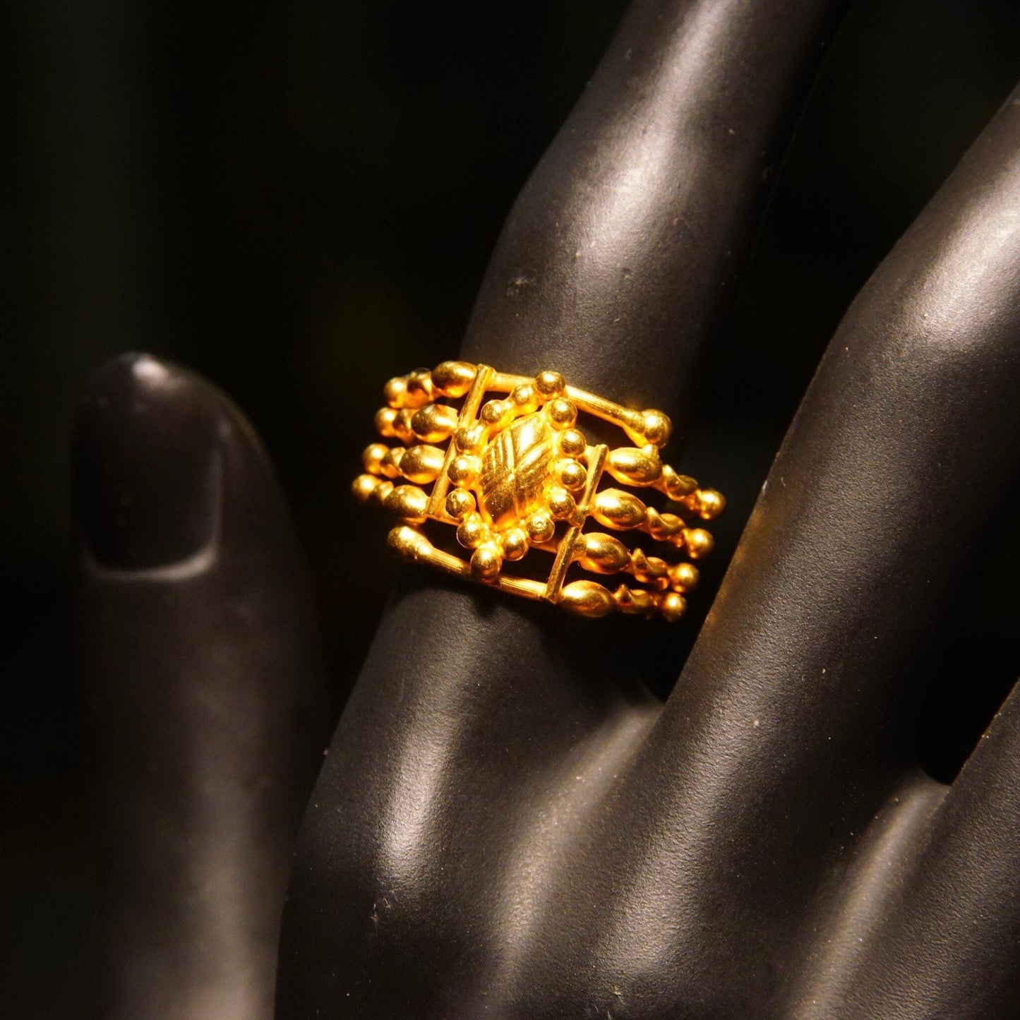 Vintage handmade 22KT yellow gold ring with intricate wire wrap design and bamboo-inspired gold drop accents on a dark silk fabric background, showcasing bohemian style craftsmanship in a close-up view, ring size 6 3/4 US.
