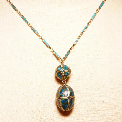 Vintage Indian mosaic turquoise brass inlay double bead pendant necklace with blue enamel silver link chain, 18 inches long, on beige textured background