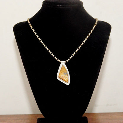 Vintage modernist sterling silver triangular pendant necklace with fossilized stone set in abstract open bezel, featuring tube bail on delicate chain.