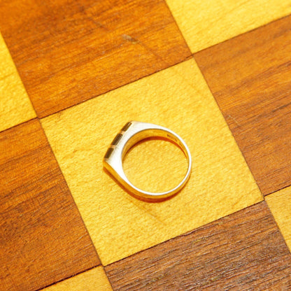 Alt text: Vintage sterling silver ring with abalone inlay on a checkerboard wooden surface