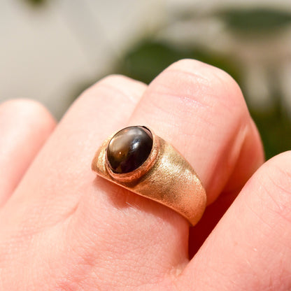 14K yellow gold men's pinky ring featuring a stunning black star sapphire cabochon with asterism effect, from estate jewelry collection, ring size 8 3/4 US.
