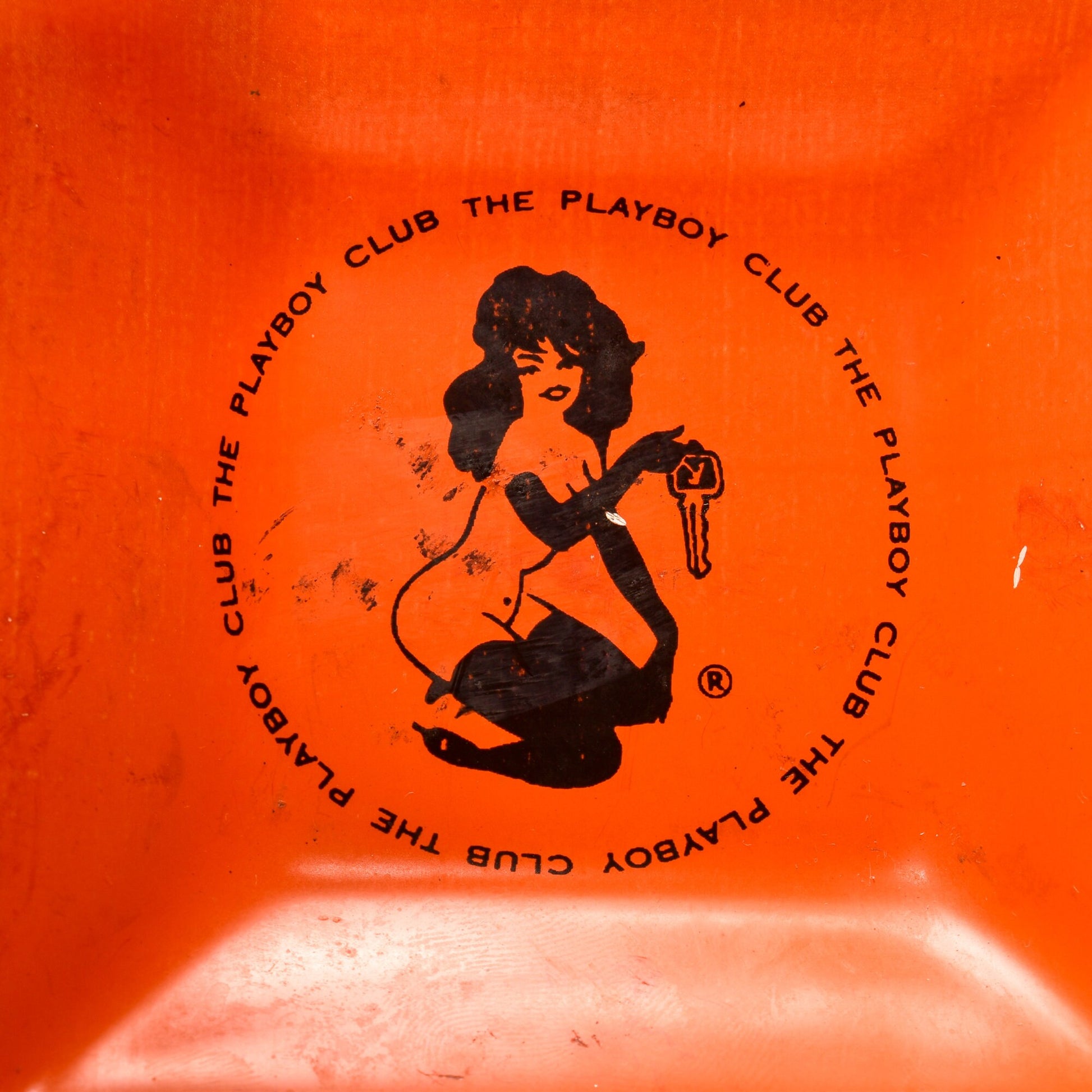 Orange glass vintage Playboy Club ashtray featuring black Femlin illustration by Leroy Neiman from the 1960s, 4.75 inch small trinket dish.