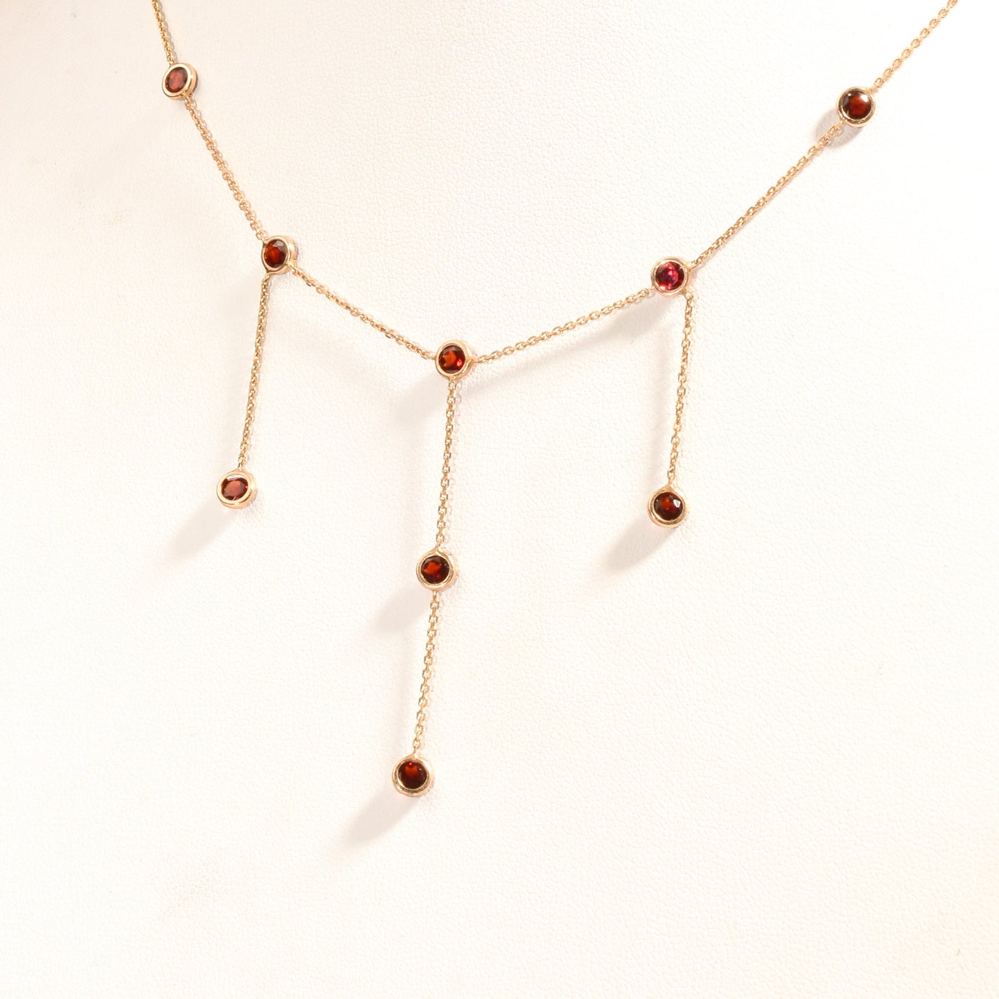 14K gold choker necklace with garnet bezel-set stations and three dangling chain tassels, delicate minimalist design, 16 inch length chain.