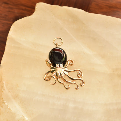 10K yellow gold 3D octopus pendant with black coral and diamond accents, aquatic themed jewelry, 38mm in size, on textured background