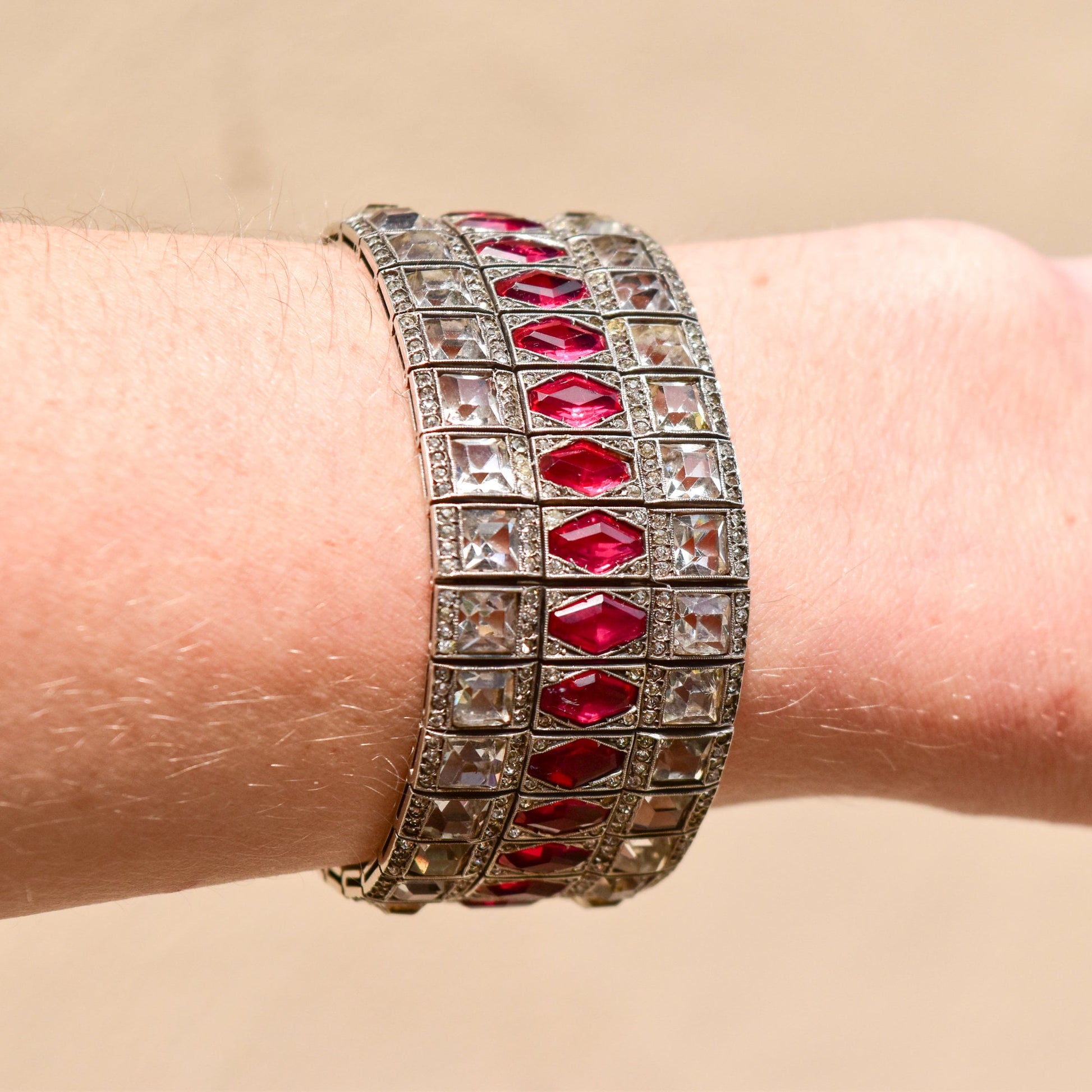 French Art Deco sterling silver bracelet with ruby paste stones in a wide articulated link cuff design, measuring 6 3/4 inches long, estate jewelry piece