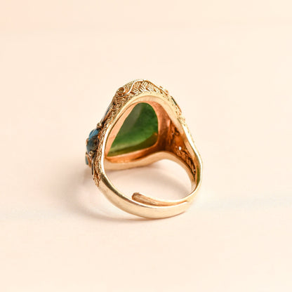 Vintage Chinese export silver gilt adjustable ring with green jade cabochon and intricate floral enamel design, fitting ring sizes 7 to 11.