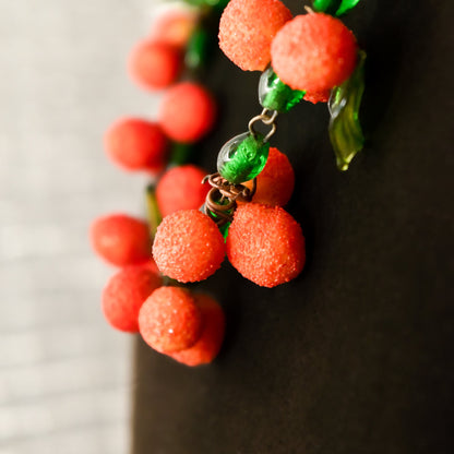 Vintage Venetian glass orange berry necklace with vibrant red round beads and green glass leaves, festive Italian mid-century statement jewelry piece measuring 18.5 inches long.