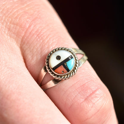 Sterling silver Little Zuni Sun Face ring with Native American design on a finger, stacking ring, size 5.25 US, with inlaid turquoise and coral.
