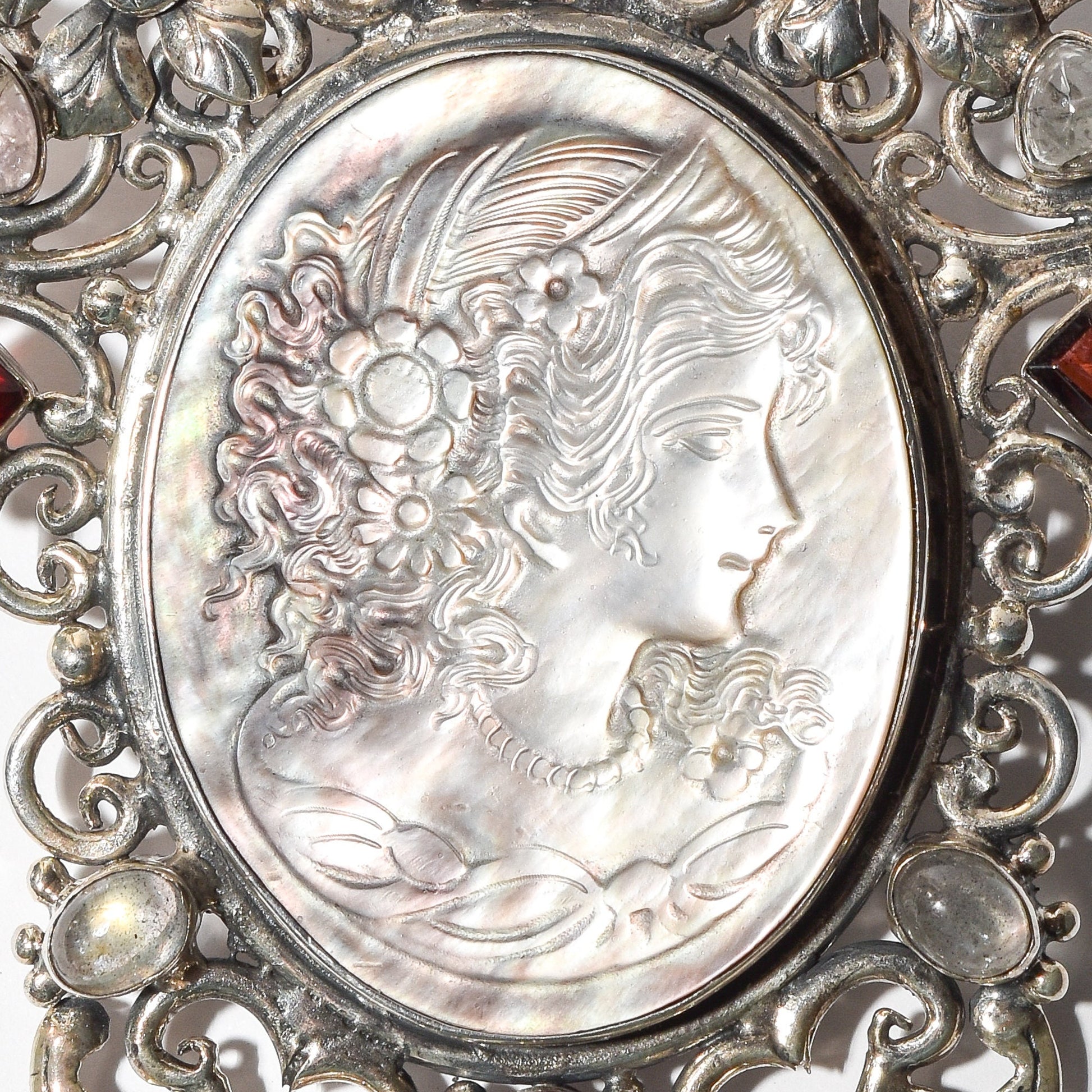 Victorian style cameo pendant brooch in sterling silver featuring a large ornate multi-stone design and a profile carving of a woman, measuring 4 inches in length.