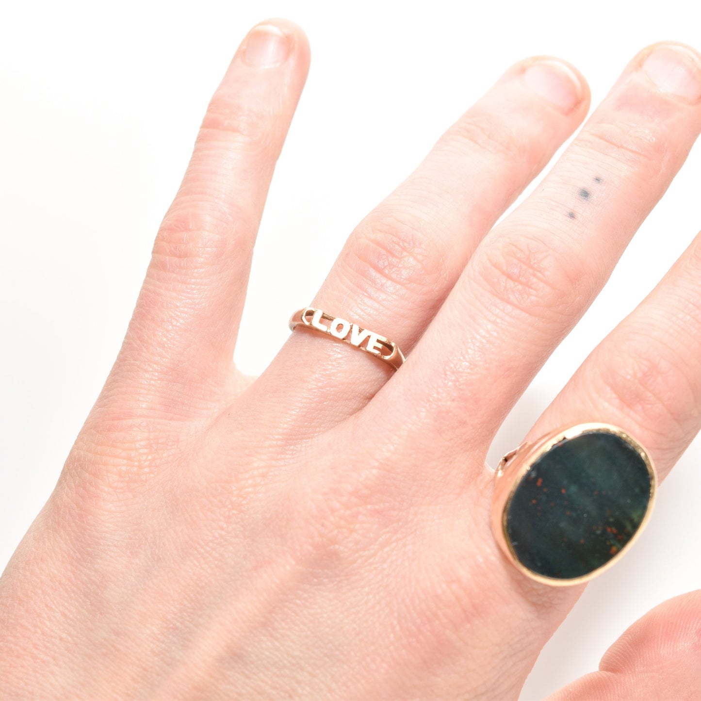 Minimalist 14K yellow gold 'LOVE' ring on a finger, paired with a large oval stone ring, ideal for stacking jewelry, Valentine's Day gift, size 6.75 US
