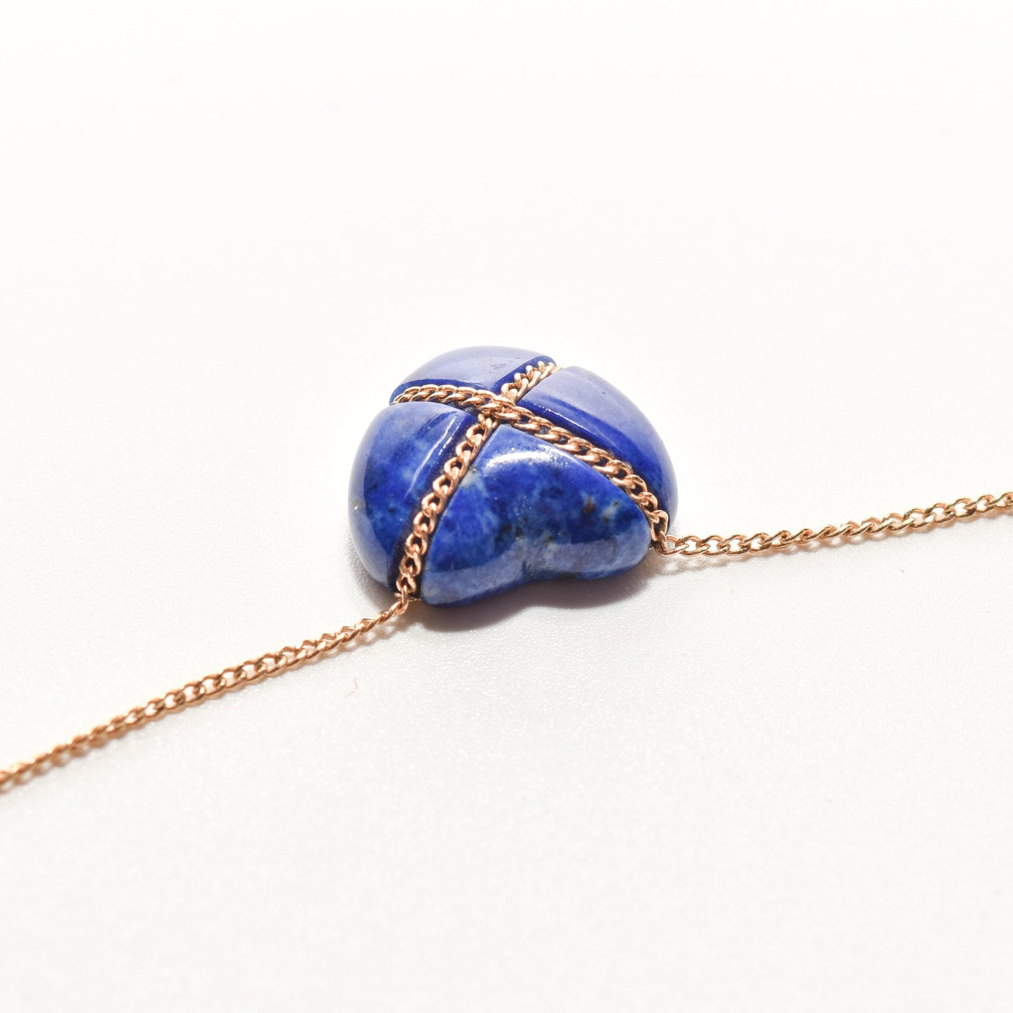 14K gold Tiffany & Co. lapis lazuli heart cross pendant on minimalist gemstone necklace against a white background